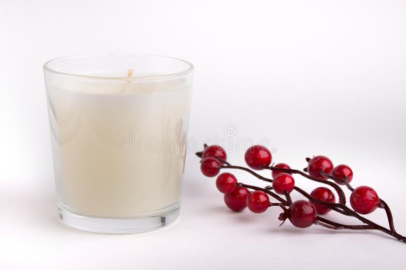 bougie-en-verre-sur-le-fond-blanc-avec-les-baies-rouges-maquette-de-produit-106738627